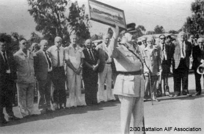 Makan 269
"Infantry Centre, Singleton - Stuart Peach holding up George Aspinall's photo of Selarang Square at naming of Parade Ground, 18/12/1982, supported by 17 2/30 Bn. Hunter Valley Men."

NX76207 - PEACH, Francis Stuart Banner (Stuart), Col. - BHQ, Adjt.
Keywords: 061222 Makan269