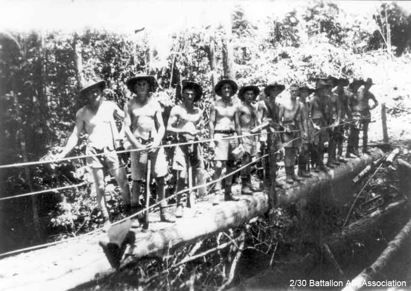 Malaya, 1941
Pioneer Platoon clearing an area that was to be occupied by the Battalion. According to A.A. MARTIN, the photo was possibly taken at Mersing in November, 1941.

One of the men in the photo is holding a rifle. It was normal practice that one or two men carried a rifle while they were working in the jungle.

Front front of row:

1) NX32446 - MARTIN, Alfred Arthur (Bob), Pte. - HQ Company, Pioneer Platoon
2) NX33519 - TRAPNELL, Robert Arthur (Bob), Pte. - HQ Company, Pioneer Platoon
3) NX31563 - MOSELEY, Henry John, Pte. - HQ Company, Pioneer Platoon
4) NX56747 - HIGGINS, Thomas Henry (Tom), Cpl. - HQ Company, Pioneer Platoon
5) NX2748 - DESPOGES, John Samuel (Darkie), Pte. - HQ Company, Pioneer Platoon
6) NX36242 - WESTON (Bright), Jack, Pte. - HQ Company, Pioneer Platoon
7) NX2535 - JAMESON, Phillip William, Pte. - HQ Company, Pioneer Platoon
8)
9)
10)
11)
12)
13) NX26862 - McCLELLAND, Alexander (Max), Pte. - HQ Company, Pioneer Platoon (he always stood with hand on hip)
Keywords: 070506