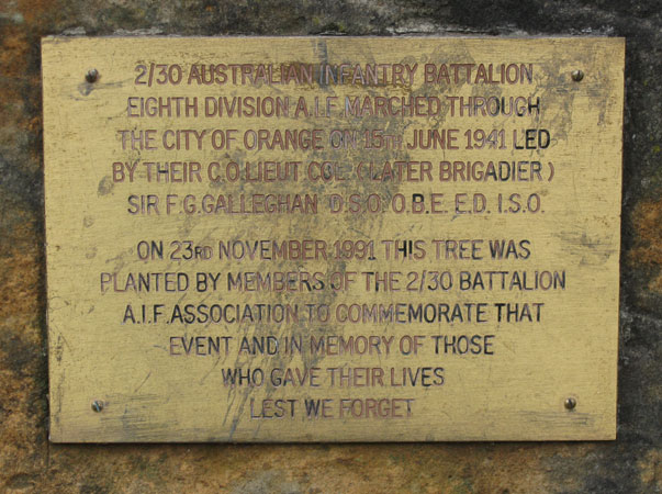 Robertson Park, Orange
The plaque on the 2/30 Battalion memorial stone, in Robertson Park, Orange, NSW, which commemorates the day that the 2/30 Battalion marched through Orange, prior to leaving for overseas service. Alongside the cairn is a golden elm, Lady G's tree, which was planted at the dedication ceremony on 23rd November, 1991.

The wording on the plaque reads:

    "2/30 Australian Infantry Battalion Eighth Division A.I.F. marched through the City of Orange on 15th June 1941 led by their C.O. Lieut. Col. (later Brigadier) Sir F. G. Galleghan DSO OBE ED ISO.
    On 23rd November 1991, this tree was planted by members of the 2/30 Battalion A.I.F. Association to commemorate that event and in memory of those who gave their lives.
    Lest We Forget."

Keywords: robertsonpark