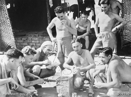 Changi Prison Camp, Singapore
Australian War memorial caption:

Changi Prison Camp, Singapore. c. 1945. Comforts and sweets are issued to released prisoners of war (POWs). Left to right: NX56259 Signalman George Wood of Ashfield, NSW; VX56541 Private (Pte) (Bluie) Ried of Launceston, Tas; NX37434 Pte Ray Ferry of Tamworth, NSW; NX43868 Pte Ray Shorples of Woolongong, NSW; VX32945 Pte Ray Ling Pack of North Melbourne, Vic; QX21688 Pte Jack Boodle of Goondiwindi, Qld; QX15277 Pte Eddie Barrett of Cairns, Qld.

Left to right:

1)	NX56259 - WOOD, George Edward, Signalman - 8 Div. Signals, of Ashfield, NSW.
2)	VX56567 - REID, Horace William, Private - 2/29 Battalion, of Launceston, TAS.
3)	NX37484 - FERRY, Raymond Joseph (Ray), Private. - 2/30 Bn., B Company, 10 Platoon, of Tamworth, NSW.
4)	NX41868 - SHARPLES, Raymond Stanley (Ray), Pte. - 2/30 Bn., C Company, 13 Platoon, of Wollongong, NSW.
5)	VX32969 - LINGPACK, Roy, Private - 2/29 Battalion, of North Melbourne, VIC.
6)	QX21608 - BOODLE, Jack, Private - 2/26 Battalion, of Goondiwindi, QLD.
7)	QX15277 - BARRETT, Ernest Edward - 27 Brigade HQ, of Cairns, QLD.
