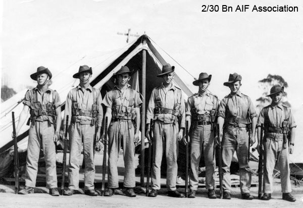 Training in Tamworth
Left to right:
1) Unknown
2) NX25821 - DONALD, Raymond Thomas (Ray), Pte. - B Coy. 12 Pl.
3) NX25744 - SANDERSON, Calvert James, Pte. - HQ Company, Carrier Platoon
4) NX30509 - SWADLING, Roy Leonard, Pte. - HQ Coy. Carrier Pl. MpD Singapore Island
5) Unknown
6) Unknown
7) Unknown
Keywords: tamworthshowground