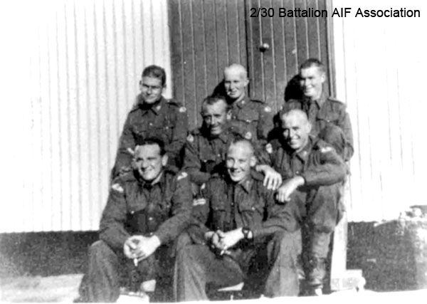A Company, 8 Platoon
On the steps of their barracks at Bathurst.

Left to right:

Back row:
1) NX65890 - GRACE, Ian Paul Desmond, Pte. - A Coy. 8 Pl. WiA Gemas, repatriated 10/2/1942
2) NX29925 - BELL, Walter Lind (Wally Mark 1), L/Cpl. - A Company, 8 Platoon
3) NX54837 - BLACKWOOD, Lindsey Burns (Dicey), L/Cpl. - A Coy. 8 Pl. KiA Gemas

Centre:
1) NX54500 - WILLIAMSON, Thomas (Tommy), Pte. - A Coy. 8 Pl.
2) NX29780 - FISHER, Mervyn Richard Errol (Dick), Pte. - A Coy. 8 Pl. 

Front row:
1) NX2589 - FERRY, Maurice Francis Joseph (Maurie), Pte. - A Coy. 8 Pl.
2) NX56869 - BLANSHARD, Douglas Copeland (Doug), Sgt. - A Coy. 8 Pl.

Keywords: NX2589FERRY