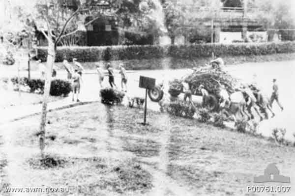 Wood carting party
Changi, Singapore. c. 1944. A "Changi chariot", or wagon put together from scrounged materials, loaded with firewood for the cookhouse. The wagon is pushed and pulled by prisoners of war (POWs). (Donor A. Mackinnon)
