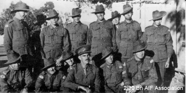 A Company, 8 Platoon
In field service uniform, at Tamworth Showground.

Left to right: 
Back row:
1)  NX31359 - EVANS, Cecil Frank (Snow), L/Sgt. - A Company, 8 Platoon
2) NX51313 - MADDEN, James Ross Harrington (Ross), Pte. - A Company, 8 Platoon (at rear)
3) NX31369 - STOKES, Cecil, Pte. (Curley) - A Company, 8 Platoon
4) NX34400 - ROBERTSON, Stuart Wilkinson, Sgt. - A Company, 8 Platoon, MiD
5) NX59213 - FEATHERSTONE, Frank Robert Henry, Pte. - Discharged 17/6/1941
6) unknown (at rear)
7) NX65890 - GRACE, Ian Paul Desmond, Pte. - A Company, 8 Platoon; WiA Gemas, Repatriated 10/2/1942
8) NX32426 - CODY, Horace Noel (Horrie), Pte. - A Company, 8 Platoon

Front row:
1) NX29922 - GIBBS, Ronald Douglas (Ron), Pte. - A Company, 8 Platoon; Medically discharged 13/10/1941; did not sail (kneeling)
2) unknown
3) NX38136 - WATSON, Edward George (Ted), Pte. - HQ Coy. Tpt. Pl. Repatriated 15/11/1941
4) NX70437 - KEARNEY, Peter Desmond (Black Prince), Capt. - 2 I/c B Coy. 
5) NX56543 - HAYES, Francis Joseph (Frank or Bully), Pte. - A Company, 8 Platoon
6) NX57453 - HAMILTON, John Allan Reginald (Allan), Cpl. - A Company, 9A Platoon. WiA Gemas
Keywords: A_Company 8_Platoon