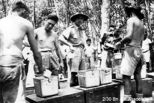 Training in the jungle in Malaya, 1941
An al fresco meal.
Left to right: 1) unknown (back to camera), 2) unknown, 3)  NX47951 - NAGLE, Athol Gervase, L/Sgt. - B Ord. Room, 4) unknown (obscrured), 5) unknown, 6) unknown (back to camera)
Keywords: Malaya