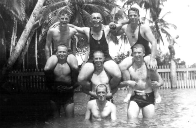 Swimming
Location unknown.

Bill Moynihan wrote:
"A day in the baths. The trees in back are coconuts."

Sitting on shoulders - left to right:
1) ?
2) NX32703 - MOYNIHAN, William James (Bill ), Sgt. - D Company, 17 Platoon
3) ?

Standing - left to right:
1) ?
2) ?
3) NX36522 - MULHOLLAND, Thomas Keith (Keith), Pte. - D Company, 16 Platoon

In water:
1) ?
Keywords: 090811a