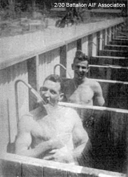 Showers at Batu Pahat
"To Bill from fond pal Abb. If only it was beer, showering pal is Cpl. Bladwell."

Left to right:
1) NX27259 - BLADWELL, Frederick Joseph, Sgt. - HQ Coy. Mortar Pl. Section Commander
2) NX15405 - McALISTER, Albert James (Abby), A/U/WO2 - HQ Coy. A/CSM.
