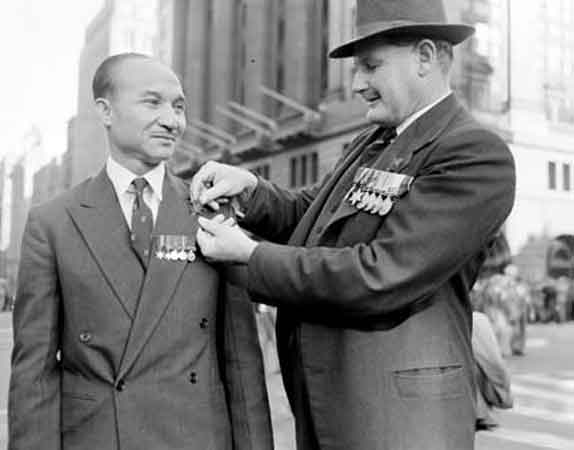 NX76207 - PEACH, Francis Stuart Banner (Stuart), Col. 
National Archives caption reads:

Lieutenant-Colonel Stuart Peach, who served in Malaya in World War II, places a sprig of rosemary, symbol of Anzac Day, on Colonel Hamid's jacket. Photographer, W Brindle. Circa 1960.
